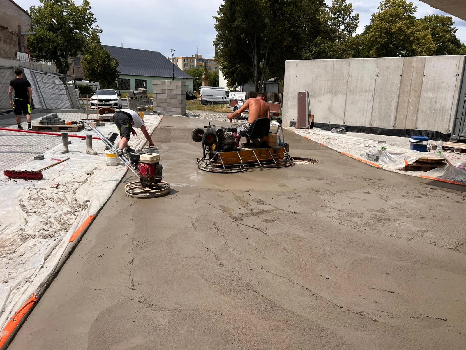 Strojní hlazení čerstvého betonu hladicími stroji před česáním — parkovací dům Olomouc